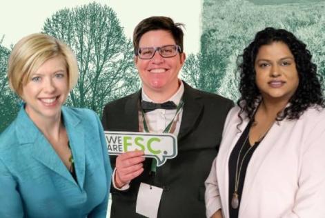 Three people are standing together smiling in front of a backdrop with forest imagery, representing FSC North America leadership.