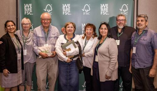 Seven attendees pose together before the FSC backdrop.